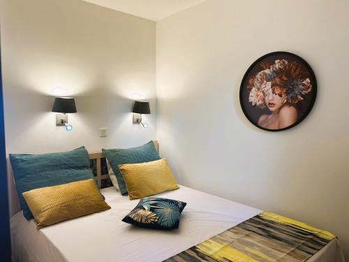 ein Schlafzimmer mit einem Bett mit einer Uhr an der Wand in der Unterkunft Gabrielle Appartements CANNES in Cannes