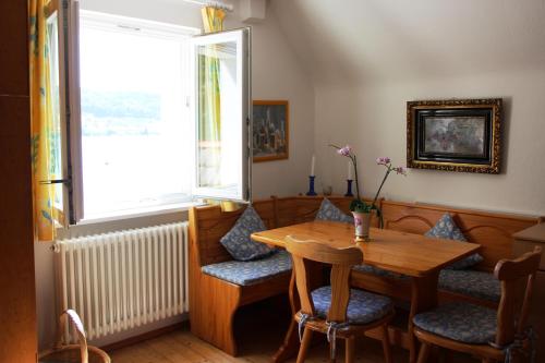 a dining room with a table and chairs and a window at Gästehaus Stöhr - Ihre Ferienwohnungen mit großem Garten und direktem Seezugang in Öhningen