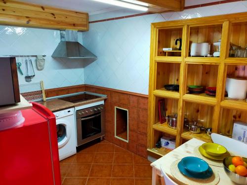 a kitchen with wooden cabinets and a red refrigerator at Casa La Vikinga in Cudillero