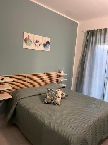 a bedroom with a green bed and a window at Approdo Felice in Formia