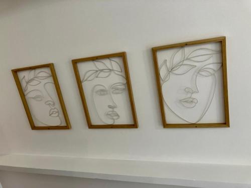 four framed drawings of faces on a wall at Chalet 190 La Belle Durbuy in Durbuy