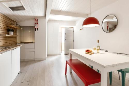 a kitchen with a white table and a red bench at Ana's House in Óbidos