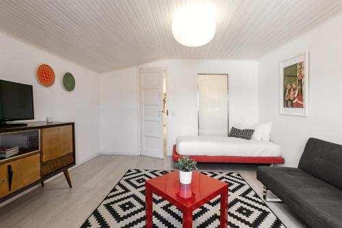 a living room with a bed and a couch at Ana's House in Óbidos