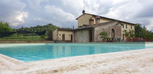 a large swimming pool in front of a house at Villa Bruna in Poggibonsi