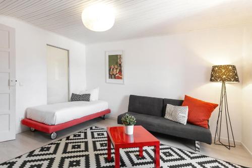 ein Wohnzimmer mit einem Sofa und einem Bett in der Unterkunft Ana's House in Óbidos