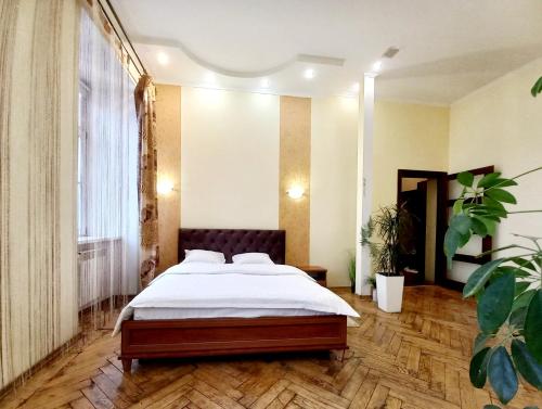 a bedroom with a bed and a large window at Ratusha Apartments in Lviv