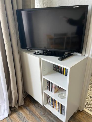 einen Fernseher auf einem weißen Entertainment-Stand mit DVD in der Unterkunft 88, Belle Aire, Hemsby - Two bed chalet, sleeps 5, bed linen and towels included - pet friendly in Great Yarmouth