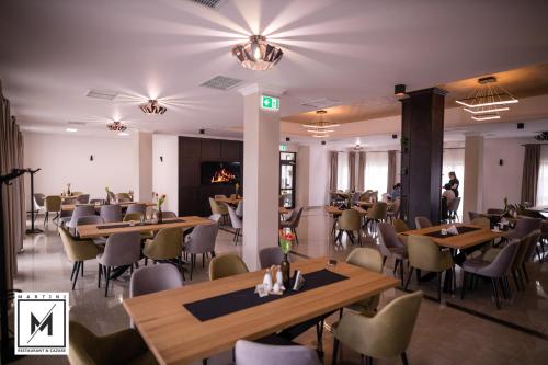 ein Restaurant mit Tischen und Stühlen in einem Zimmer in der Unterkunft Martini Restaurant & Cazare in Sebeşel