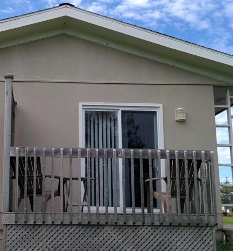 a house with a balcony with two chairs on it at Sunny Isle Motel in Summerside