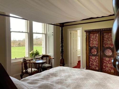 a bedroom with a bed and a table and a window at Blarcreen in Oban