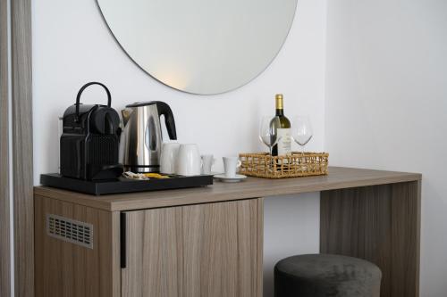 - une table avec une cafetière et une bouteille de vin dans l'établissement Amalphi Corfu City Living by Konnect, à Corfou