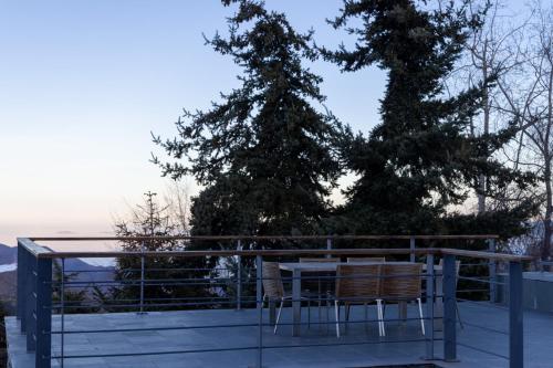 a table and chairs on a balcony with a tree at Casa Farellones Lower Apartment in Farellones