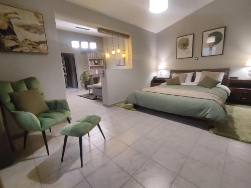 um quarto com uma cama, uma cadeira e um sofá em Wine Reflections Apartment near Nafplio em Néa Kíos