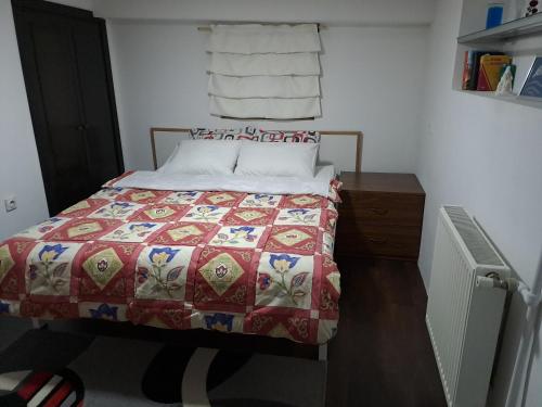 1 dormitorio con 1 cama con colcha roja y blanca en Svetlana's Apartments en Jurumleri