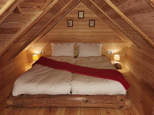łóżko na poddaszu domku z bali w obiekcie Apartma kašča w mieście Domžale