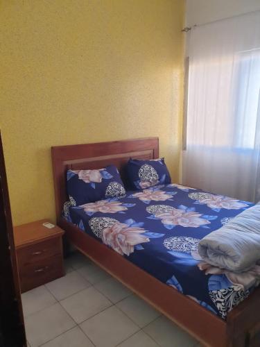 um quarto com uma cama com um edredão azul em Mousse Diop em Dakar