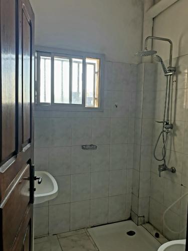 uma casa de banho com um chuveiro e um lavatório. em Mousse Diop em Dakar