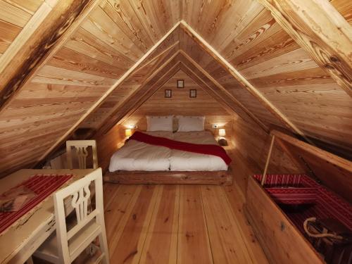 a bedroom with a bed in a wooden attic at Apartma kašča in Domžale