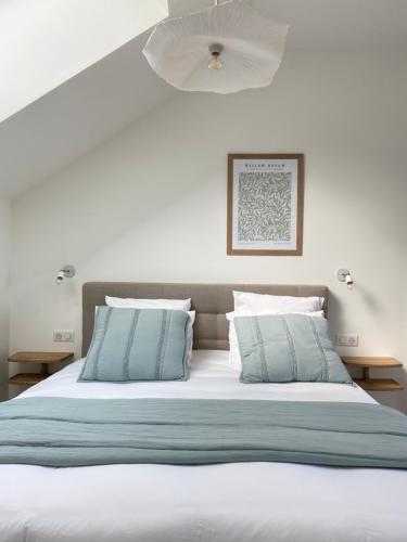 uma cama com lençóis e almofadas azuis e brancos em La Cour Tellier em Rilly-la-Montagne