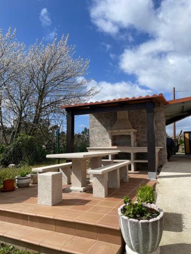 un refugio de picnic con bancos y mesa de picnic en Casa con vistas a Portugal, en Arbo