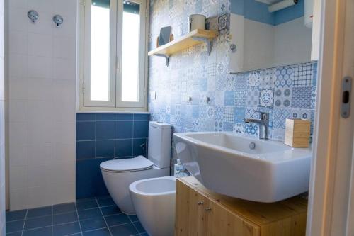 a bathroom with a white toilet and a sink at la finestra sul mare a marzamemi in Marzamemi