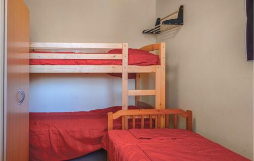 カルカトッジョにあるAmazing Home In Calcatoggio With 2 Bedrooms And Wifiのベッドルーム1室(二段ベッド2台、赤いベッド1台付)