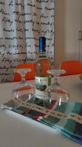a bottle of alcohol and two glasses on a table at La Casa di Milly in Sori