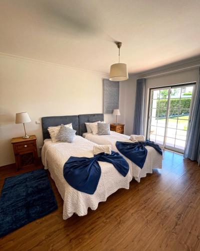 a bedroom with two beds with blue pillows on them at Oliva House in Lagos
