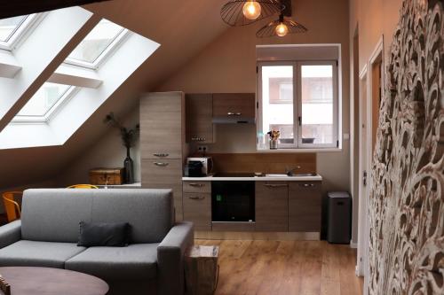 a living room with a couch and a kitchen at Loft Design Typikindi in Douai