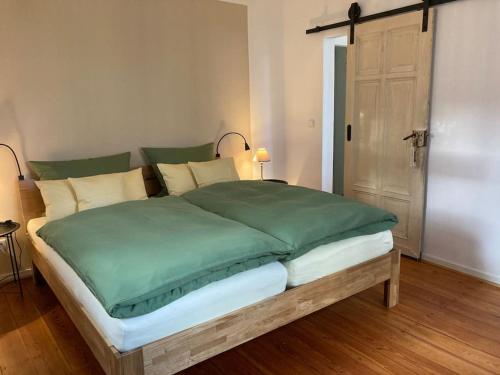1 dormitorio con 1 cama grande con sábanas verdes en Altes Winzerhaus Lenz en Pünderich