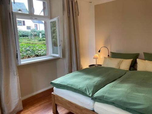 Un dormitorio con una cama verde y una ventana en Altes Winzerhaus Lenz en Pünderich