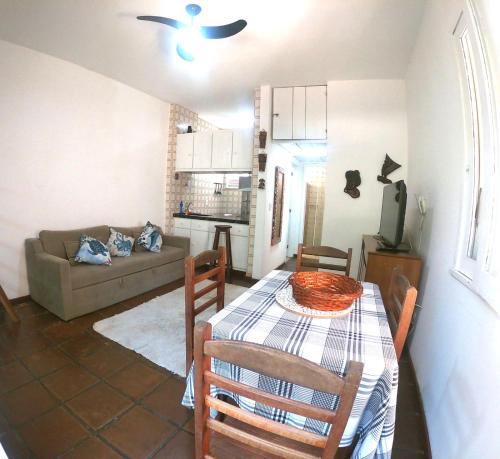 uma sala de estar com uma mesa e um sofá em Apartamento Cabo Frio em Cabo Frio