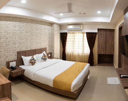 a hotel room with a bed and a television at HOTEL BRAHMAPUTRA MADHUKALYA in Guwahati