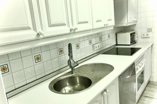 a kitchen with a sink and white cabinets at MI CAPRICHO BEACHFRONT- 9D Apartment with sea views - Costa del Sol in La Cala de Mijas