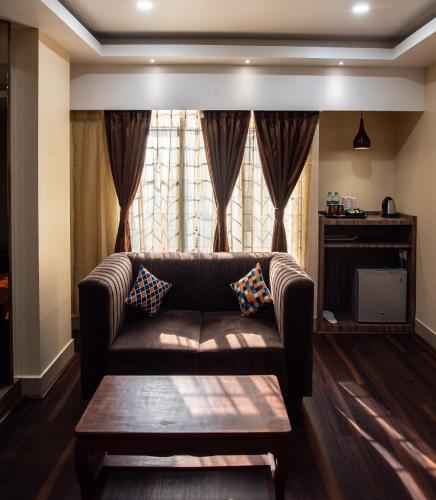 a living room with a couch and a window at HOTEL BRAHMAPUTRA MADHUKALYA in Guwahati