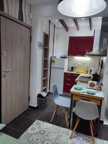 een kleine keuken met een tafel en stoelen en een deur bij Super Stylish Studio II in Thessaloniki