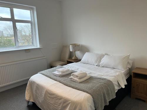 a white bedroom with two towels on a bed at Spacious 3 Bed Flat in Greenwich in London