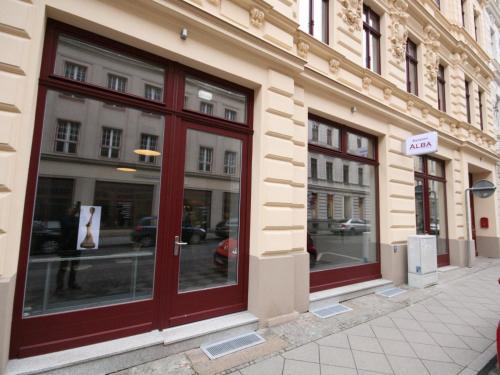a store front with red doors on a street at Pension Alba in Görlitz
