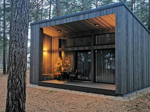a house with a table in the middle of a forest at GaujaUpe 2 in Gauja