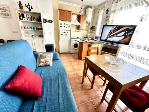 sala de estar con sofá azul y mesa en COSY APARTMENT IN CITY CENTER, en Ayamonte