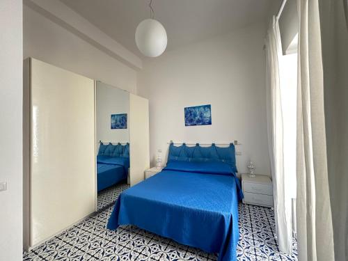 Un dormitorio con una cama azul y un espejo. en CANNETO BLU, en Lipari