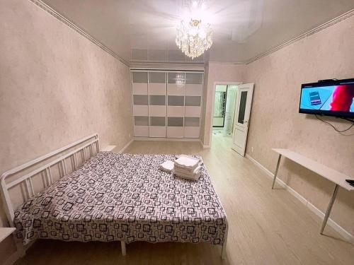 a room with a bed and a tv in it at Promenade Expo in Prigorodnyy