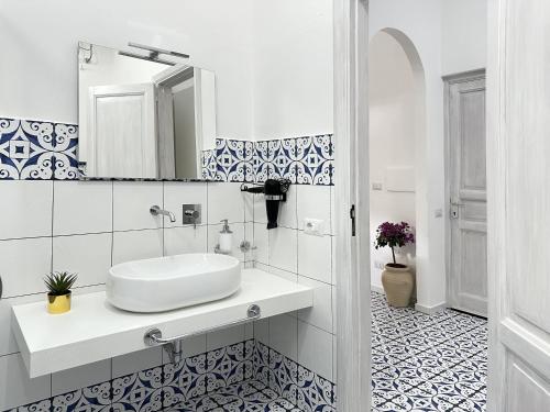 Un baño blanco con lavabo y espejo. en CANNETO BLU, en Lipari
