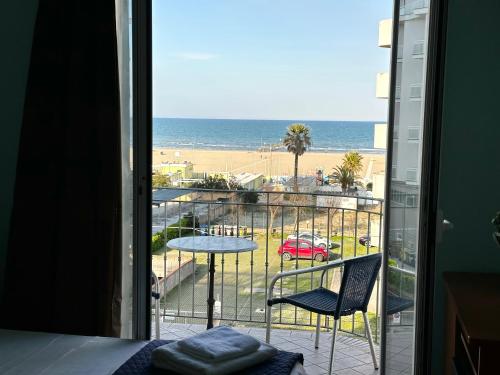 um quarto com uma varanda com vista para a praia em Hotel Blue Moon em Rimini