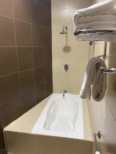 a bath tub in a bathroom with towels at El Castillo de Nallig in Gualaceo