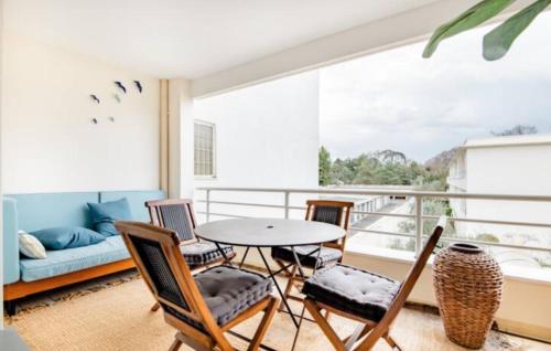 a balcony with a table and chairs and a couch at Chambres Élégance - Parc Bordelais in Bordeaux