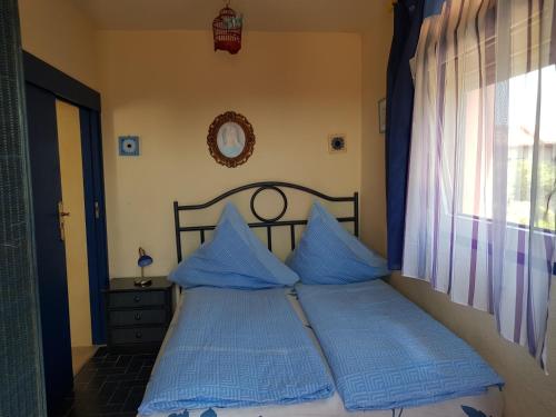 プラヤ・デアロにあるVilla Casa rosa Mariaのベッドルーム1室(青い枕のベッド1台、窓付)