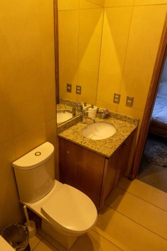 a bathroom with a toilet and a sink and a mirror at Casa Farellones in Farellones