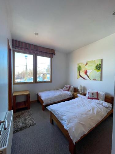 a bedroom with two beds and a window at Casa Farellones in Farellones