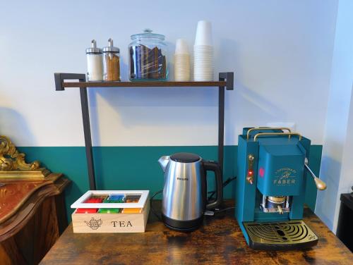 una cafetera sentada en una mesa de madera con una cafetera en Nuccia Urban Loft en Nápoles